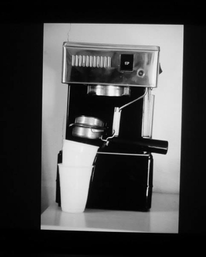 Schwarz-Weiß-Aufnahme einer klassischen Espressomaschine mit Plastikbecher – Stillleben- und Produktfotografie der Fotografin aus Bonn. kamaka.info