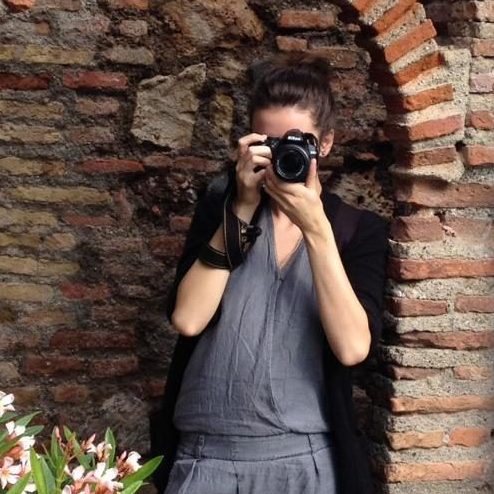 Malin Kalwa Fotografin Bonn mit Nikon Kamera vor alter Backsteinmauer kamaka.info