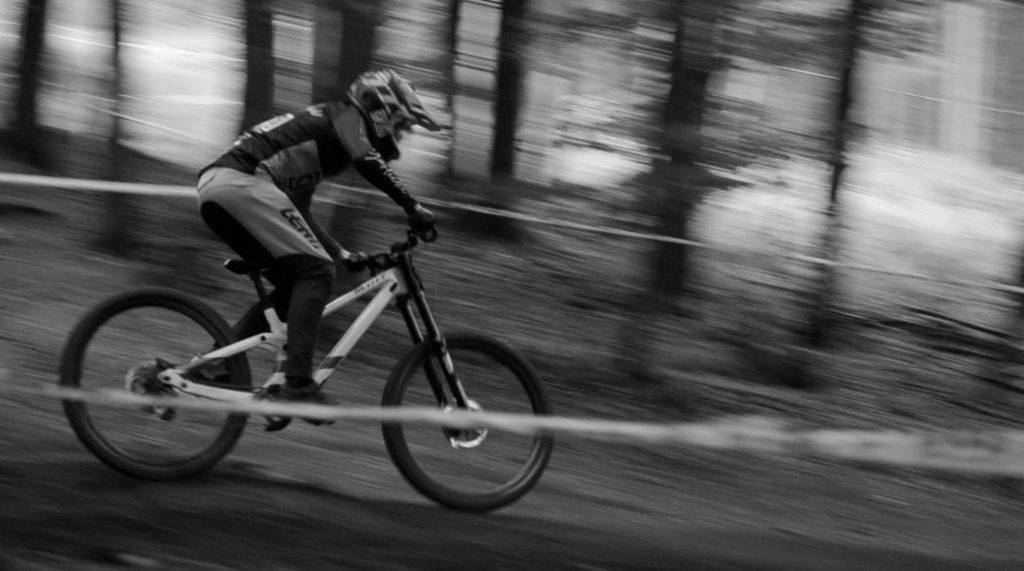 Eventreportage Winterberg: Schwarz-Weiß-Foto eines Downhill-Fahrers mit Panning-Effekt | Fotografin Bonn kamaka.info