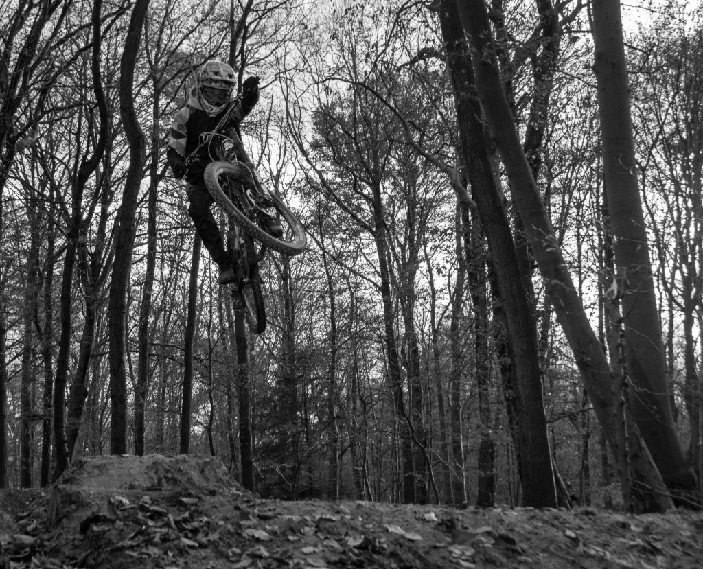 Social Media Fotografie Köln: Mountainbiker beim Dirt Jump im Wald | Schwarz-Weiß-Aufnahmen von Fotografin Bonn