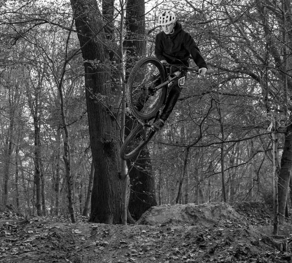 Professionelle Social Media Fotos: Dynamische Schwarz-Weiß-Aufnahme eines Mountainbikers hoch in der Luft | Fotografin Bonn