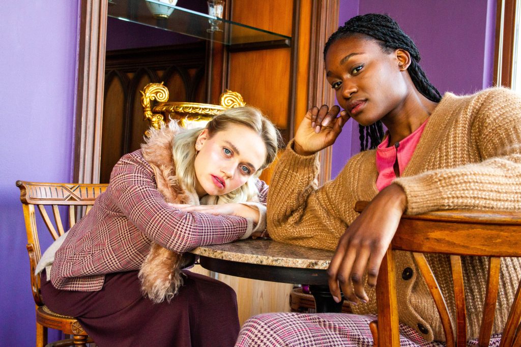 Fashion Fotografie Shooting Bonn: Zwei Models in herbstlicher Mode am Tisch, aufgenommen von Konzeptfotografin Malin Kalwa.