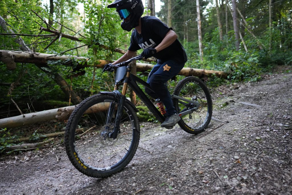 Karla Malin Kalwa kamaka Fashion Fotografie: Mountainbiker mit Kali Protectives Helm und Fox Racing Hose auf Waldweg
