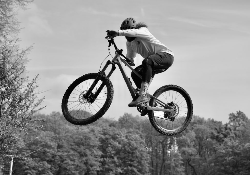 Konzeptionelle Brand-Fotografie Outdoorsport – Mountainbiker in der Luft von Fotografin Bonn kamaka.info