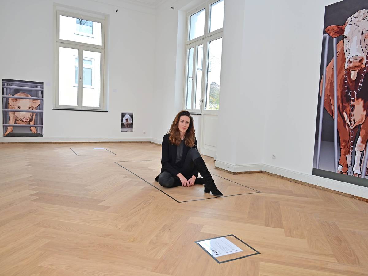 Fotografin Karla Malin Kalwa sitzt in der Ausstellung über Massentierhaltung im Gründerzeithaus Bonn Bad Godesberg