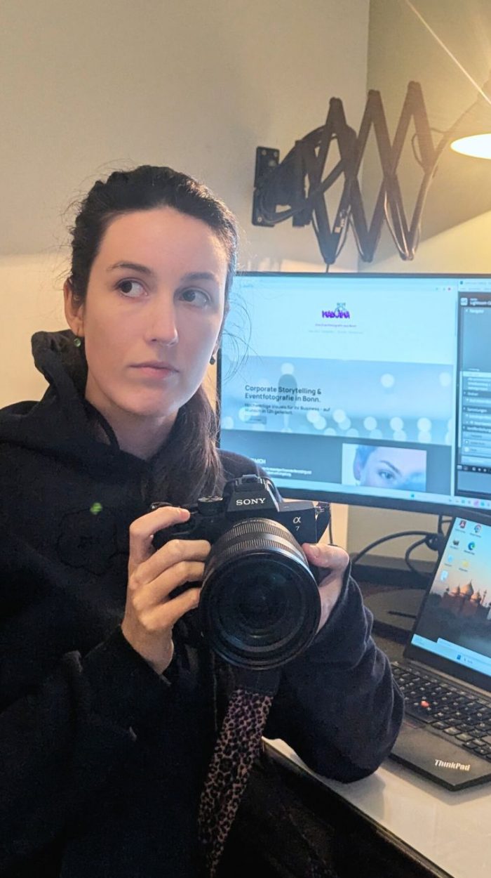 Malin Kalwa Ihre Fotografin sitzt am Schreibtisch mit ihrer Kamera und bearbeitet Ihre Fotos